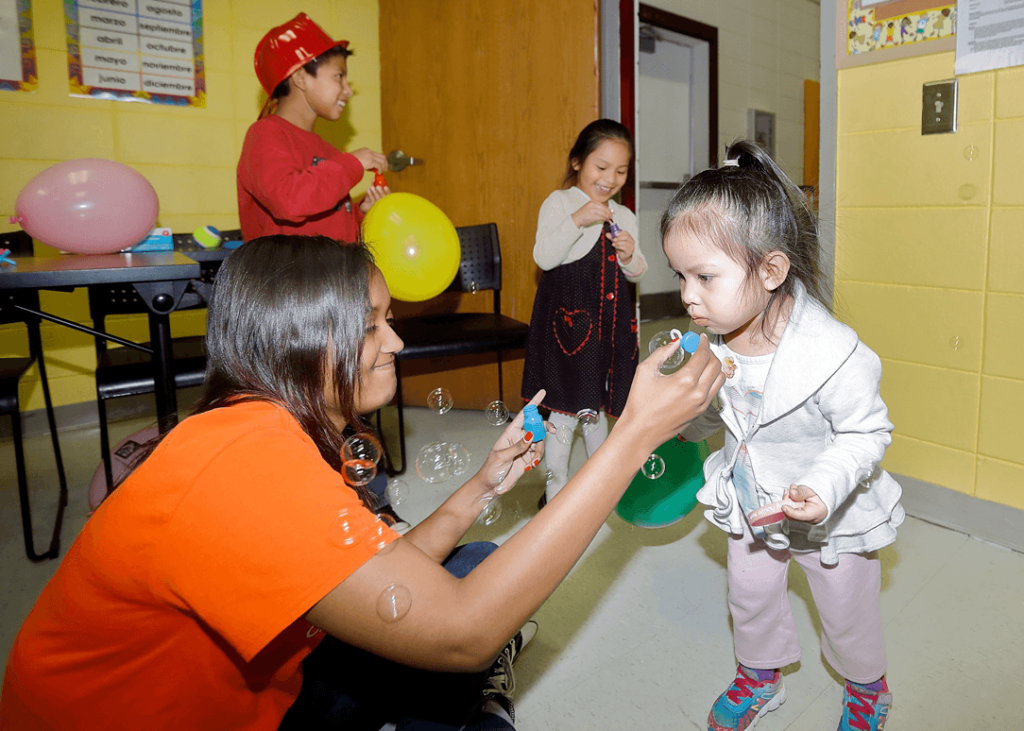 A Mercer student plays with children at the Hispanic Health Fair.