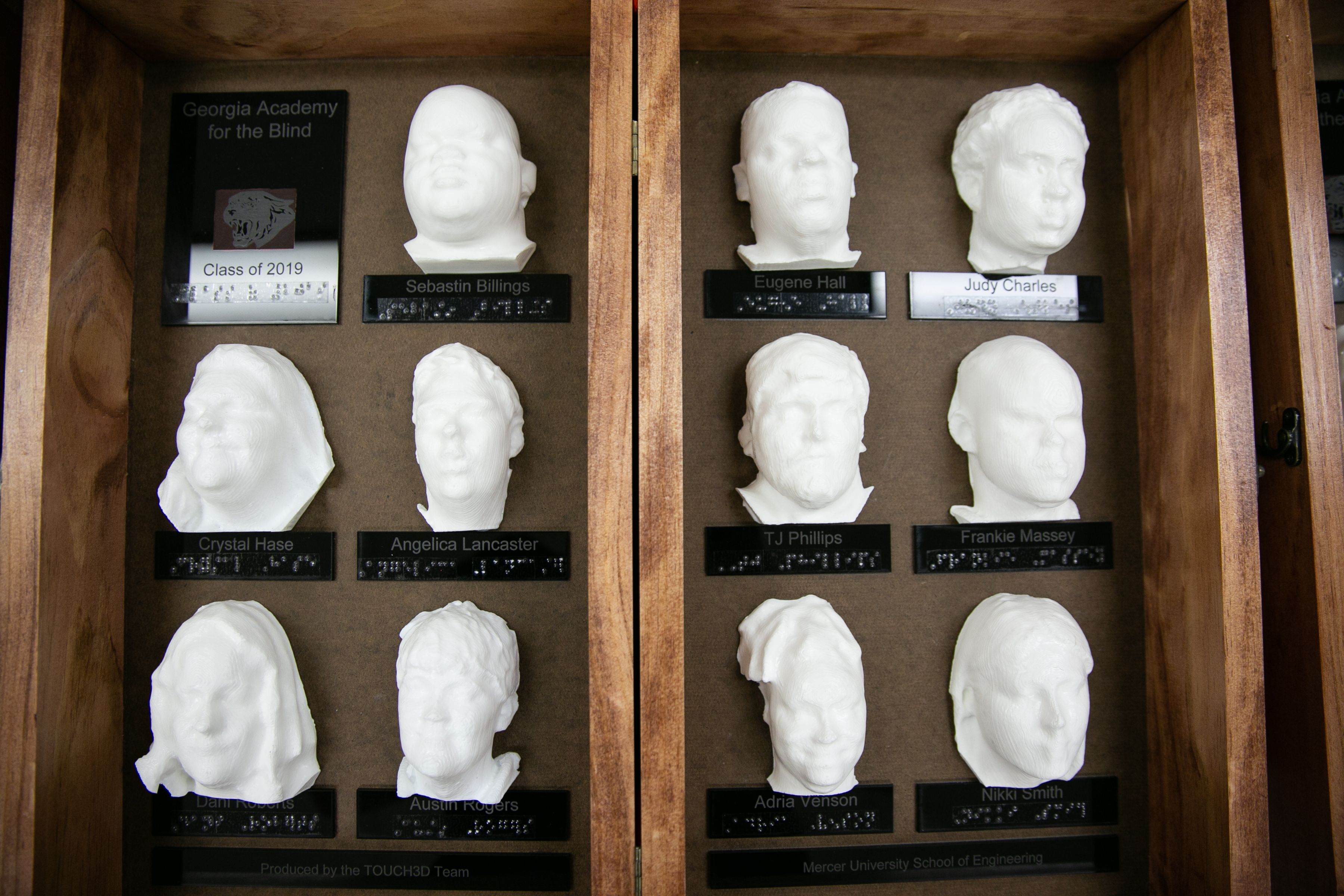 The 3D yearbook features face models of 11 Georgia Academy for the Blind Class of 2019 graduates inside a wooden case.
