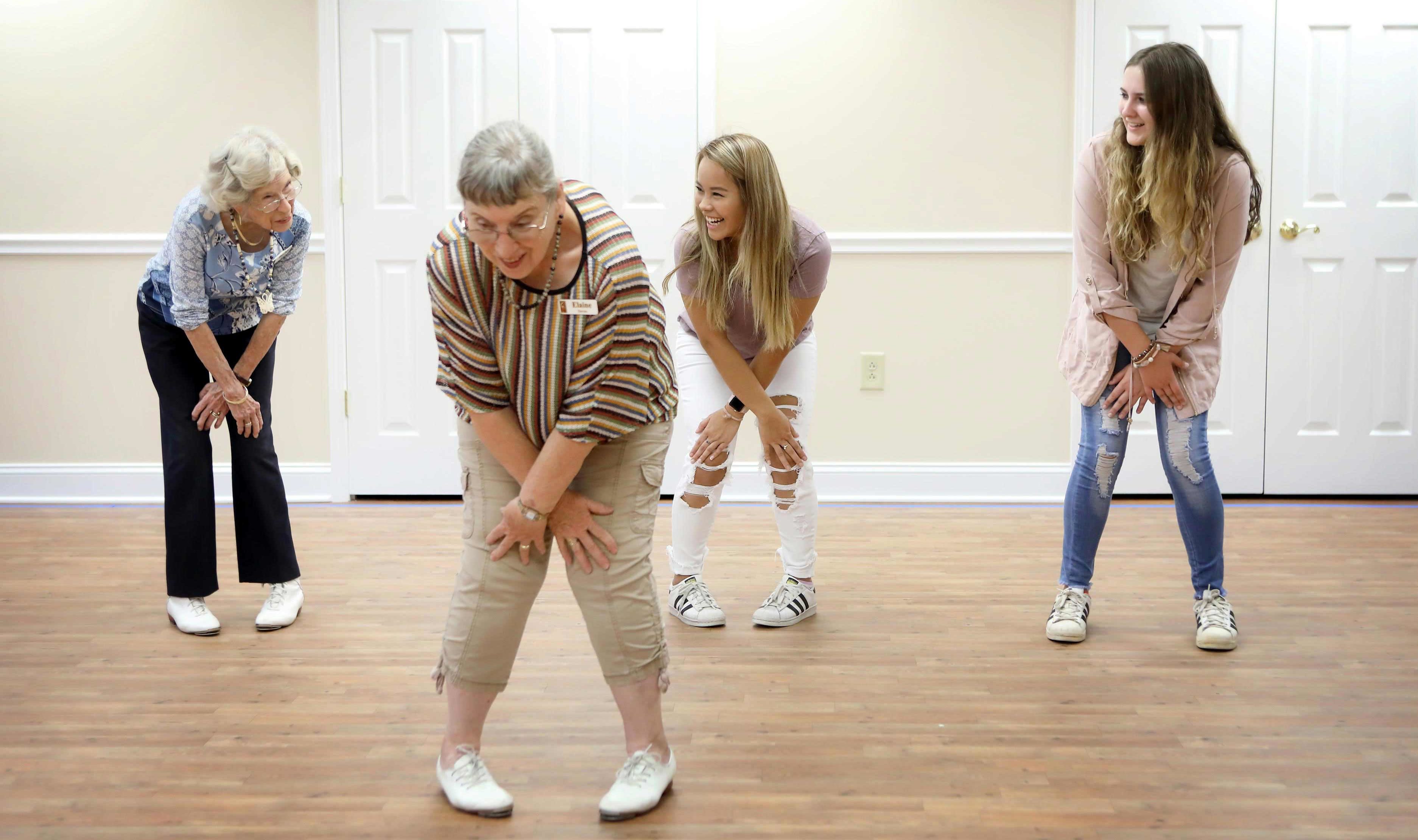 Mercer students Ava Nguyen, middle, and Elise Colquitt, right, take a clogging class with residents at Carlyle Place. The students are the first from Mercer to live on the Carlyle Place campus as part of a new program.