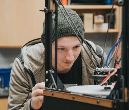 Brandon Matthews works on his 3D printer inside the robotics club lab at Mercer.